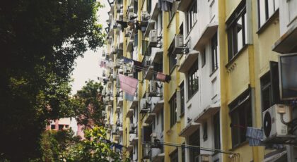 Colorful apartment building facade in urban Singapore with laundry visible, capturing city life.