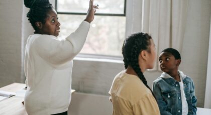 Teacher and students engaged in a learning session indoors with focus and interaction.