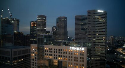 Evening view of Singapore's skyline with prominent Conrad and Suntec buildings, captured at dusk.