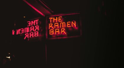 Vibrant neon sign of The Ramen Bar glowing at night in Dublin.