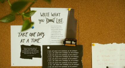 A corkboard with motivational quotes, notes, and film negatives, fostering creativity and reflection.