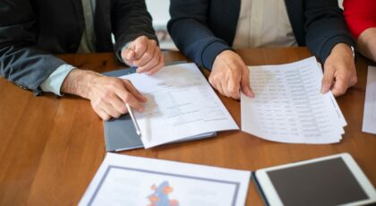 Two business professionals discussing and reviewing documents during a meeting.