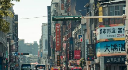 Dynamic city street scene with bustling traffic and vibrant signage in Taipei, Taiwan.
