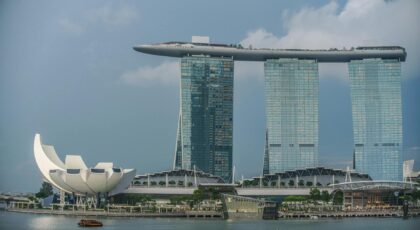 View of Marina Bay Sands and ArtScience Museum in Singapore's skyline with a boat on the bay.