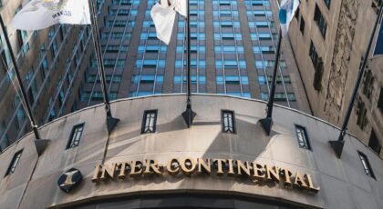 Low angle shot of InterContinental Hotel in Chicago, showcasing architectural design and flags.