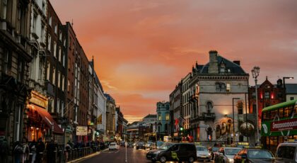 Vibrant city street in Dublin, Ireland during a stunning sunset, showcasing urban life.