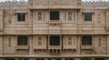 Impressive stone facade of a palace hotel in Jaisalmer, showcasing intricate architectural details.