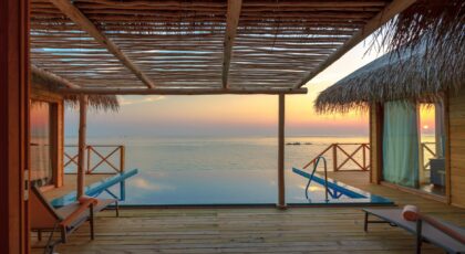 Stunning view of a luxury overwater villa in the Maldives at sunset, perfect for a tropical vacation.