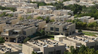 Aerial view of modern residential villas surrounded by greenery in Dubai.