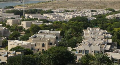 An expansive aerial view of a residential community surrounded by greenery in Dubai, UAE.