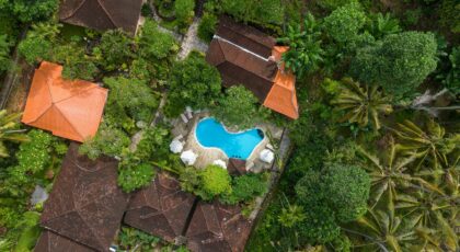 Stunning aerial shot of tropical villa with pool surrounded by lush greenery in Bali.