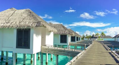 Scenic view of luxurious overwater bungalows on a sunny tropical day, ideal for travel and relaxation.